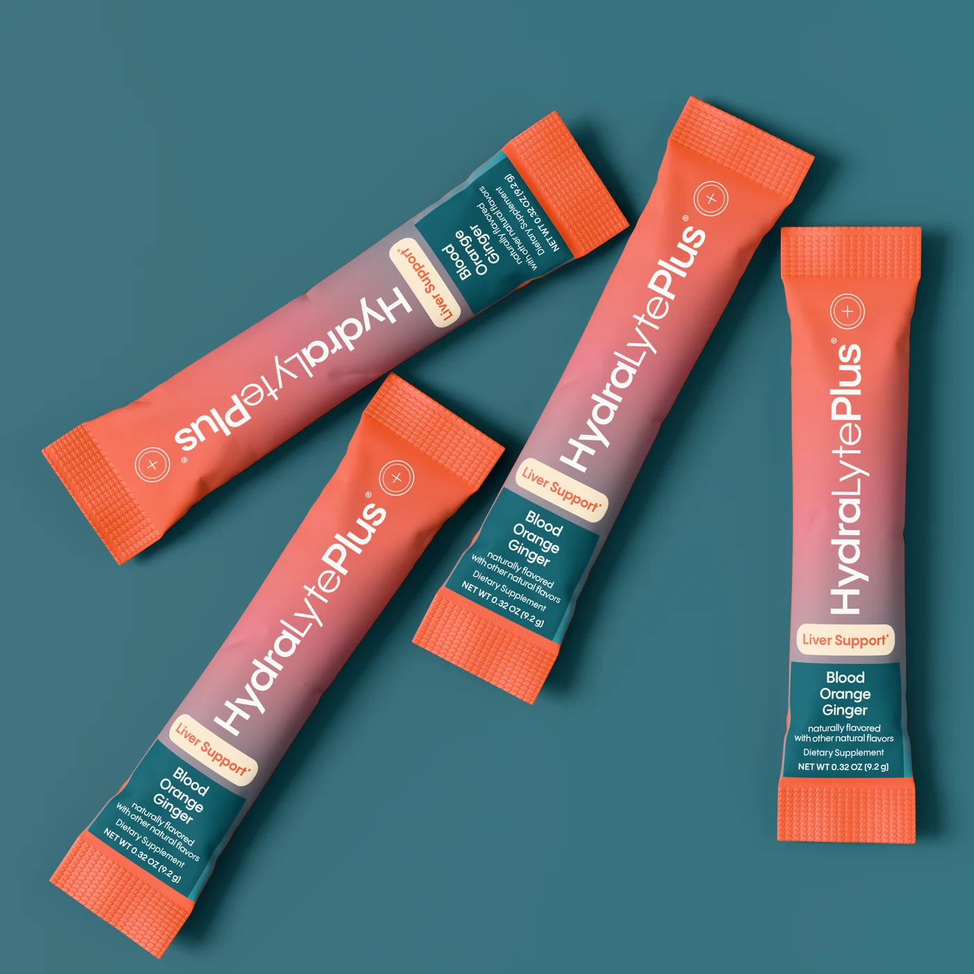 Four HydraLytePlus stick packs scattered on deep teal