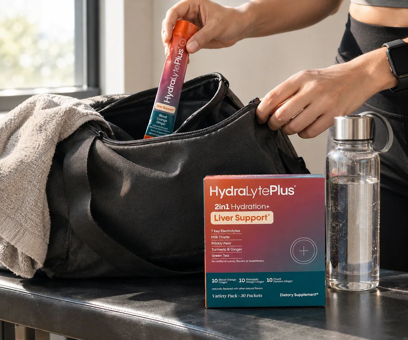A HydraLytePlus stick pack taken from a gym bag beside the carton and a water bottle